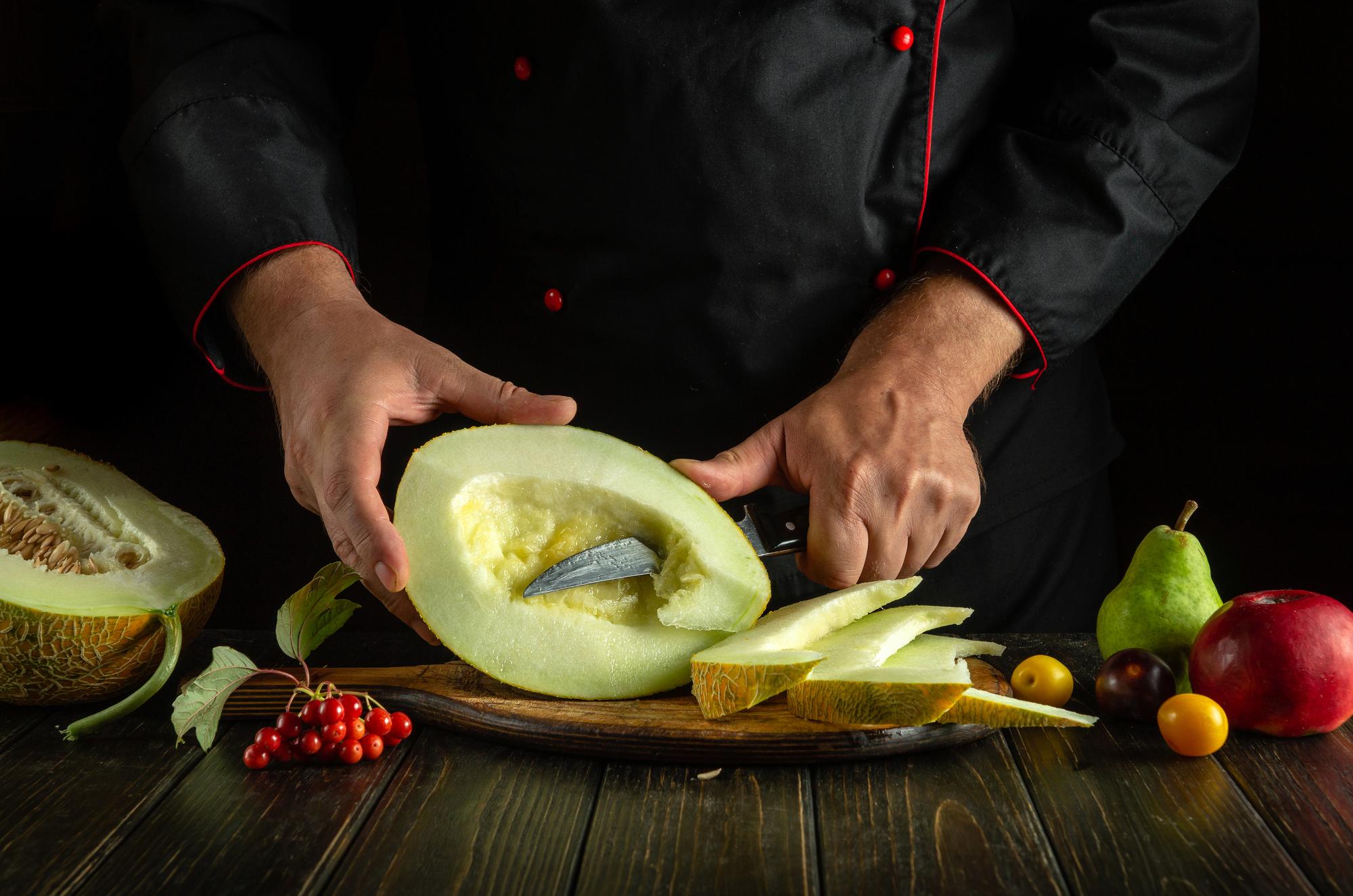 Dettaglio: mani dello chef che affettano